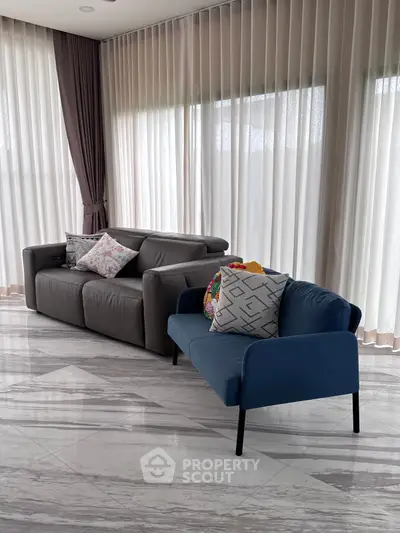 Elegant living room with modern furniture and floor-to-ceiling curtains