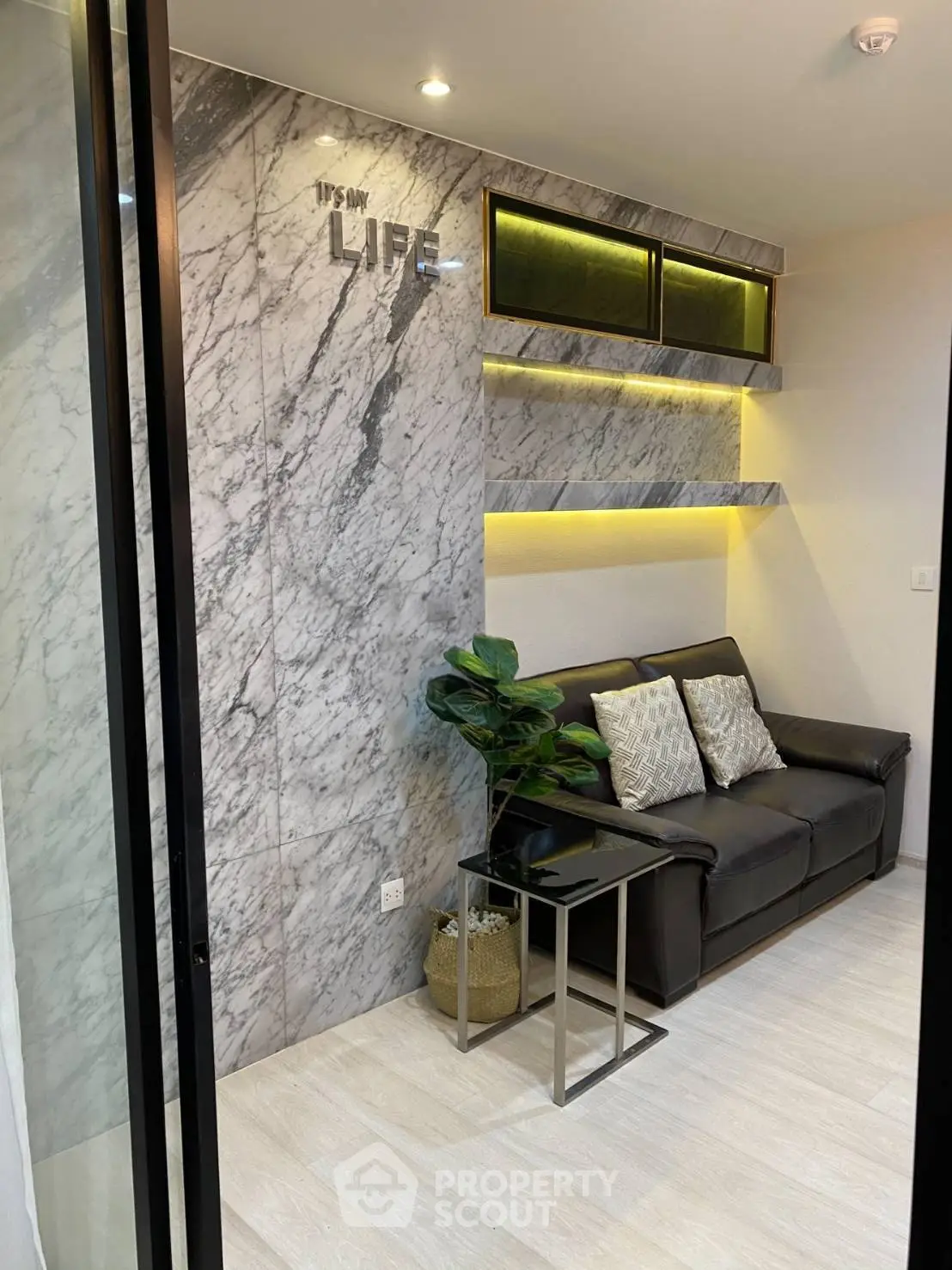 Modern living room with marble accent wall and cozy leather sofa