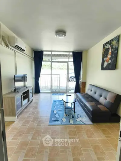Modern living room with stylish sofa, TV unit, and large window for natural light.