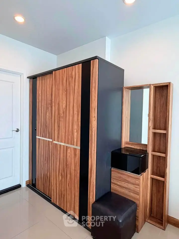 Modern bedroom with sleek wooden wardrobe and matching vanity set, perfect for stylish storage solutions.