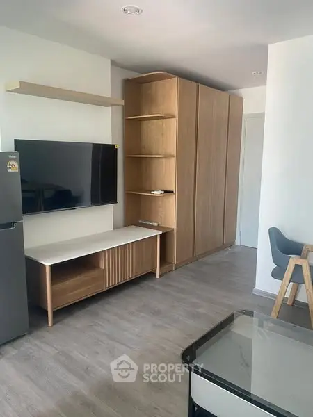 Modern living room with sleek furniture and wall-mounted TV in a stylish apartment.