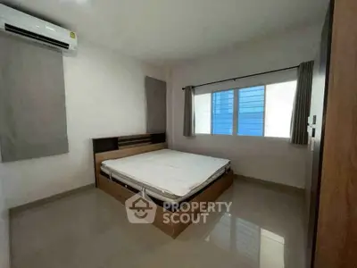 Spacious bedroom with modern design and large window for natural light.