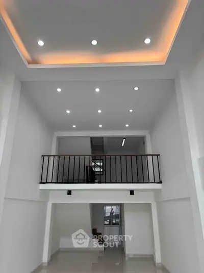 Modern two-story interior with high ceiling and recessed lighting