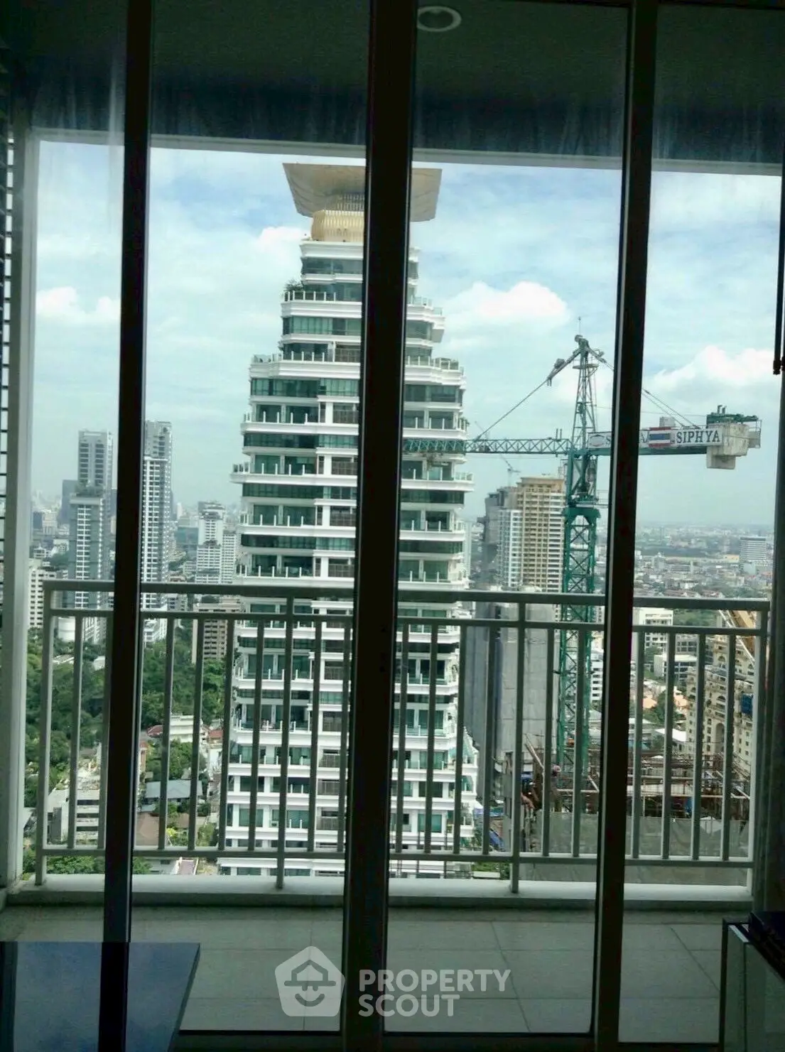 Stunning cityscape view from a modern apartment balcony with high-rise buildings.