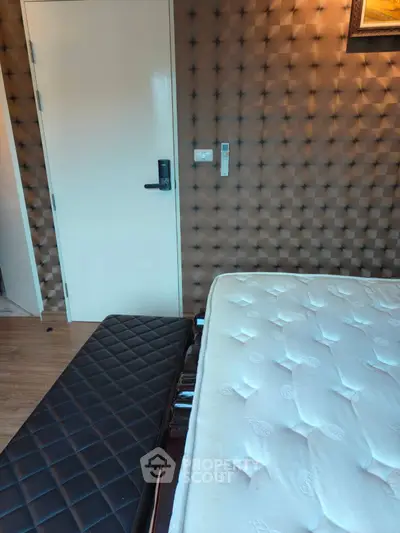 Modern bedroom with stylish padded wall and comfortable mattress
