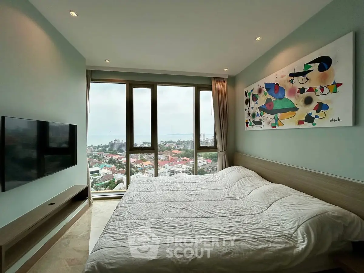 Spacious bedroom with stunning city view and modern art decor.