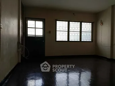 Spacious empty room with large windows and dark flooring, ideal for customization.