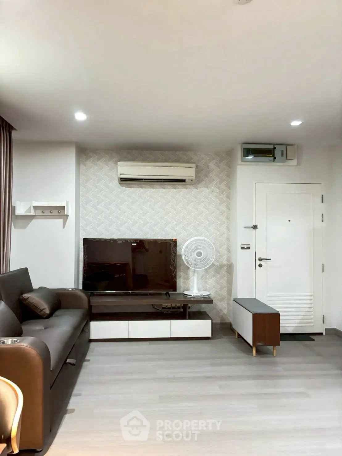 Modern living room with sleek furniture and air conditioning, perfect for urban living.