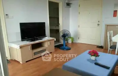 Cozy living room with TV and fan, featuring wooden flooring and modern decor.