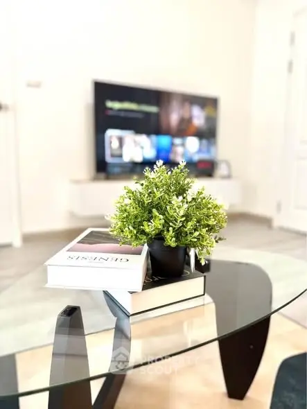 Modern living room with glass coffee table and TV, stylish decor