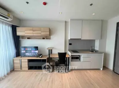 Modern living room with sleek furniture and integrated kitchen in a stylish apartment.
