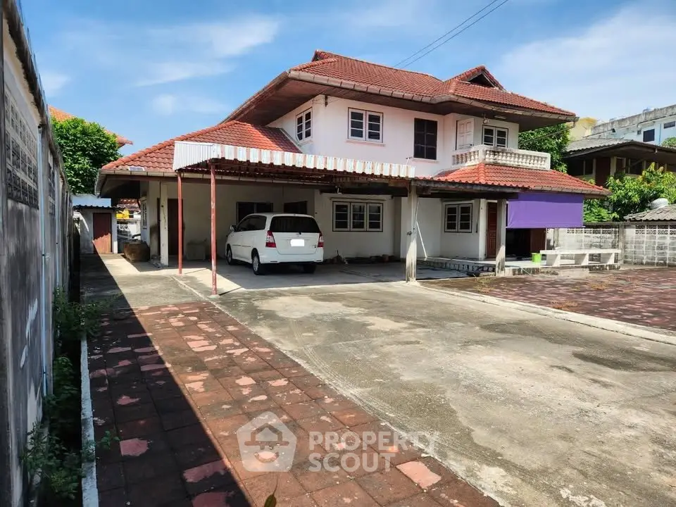 Charming two-story house with spacious driveway and carport in a serene neighborhood.