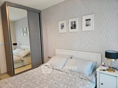 Modern bedroom with stylish decor and mirrored wardrobe in a cozy apartment.
