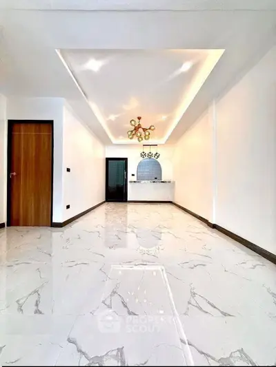 Spacious modern living room with elegant marble flooring and stylish ceiling lights.