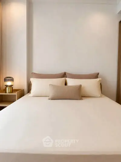 Cozy and elegant bedroom with neutral tones and soft lighting, perfect for relaxation.