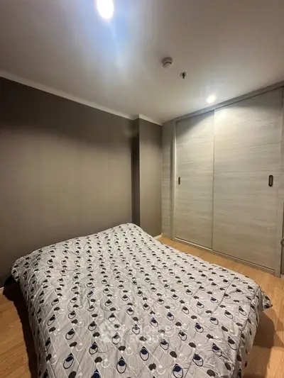 Cozy bedroom with modern decor and ample closet space in a stylish apartment.