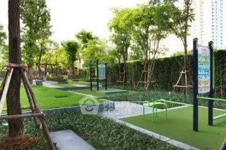 Lush green garden area with exercise equipment in modern residential complex.