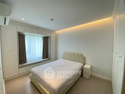 Modern bedroom with stylish lighting and window seat in a cozy apartment.