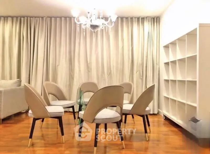 Elegant living room with modern chairs and chandelier, perfect for stylish gatherings.