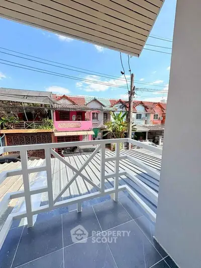 Charming balcony with street view in a vibrant neighborhood, perfect for relaxation and enjoying the outdoors.