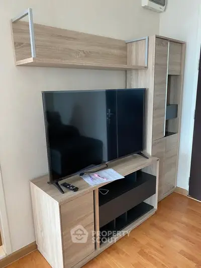 Modern living room with sleek wooden TV stand and flat-screen television, perfect for cozy entertainment.
