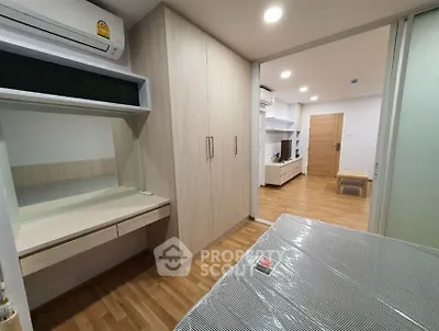 Modern bedroom with wooden flooring and built-in wardrobe in a stylish apartment.