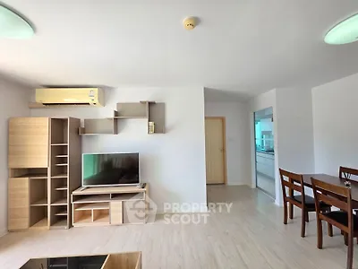 Spacious living room with modern furniture and dining area in open layout apartment.