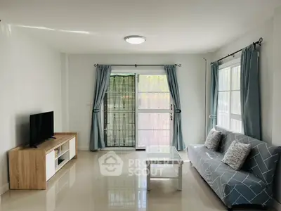 Bright and modern living room with sleek furniture and large windows.