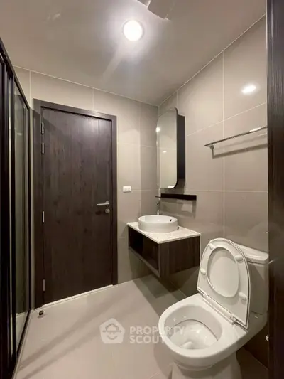 Modern bathroom with sleek fixtures and neutral tones, featuring a glass shower and stylish vanity.