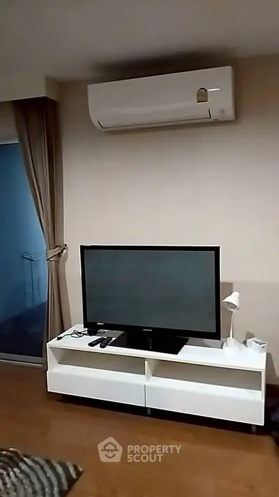 Modern living room with TV and air conditioning unit, perfect for relaxation.