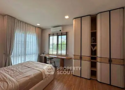 Spacious bedroom with modern furniture and large windows for natural light.