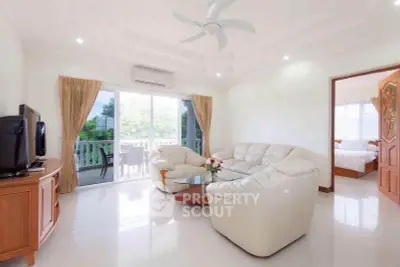 Spacious living room with elegant furniture and balcony view, perfect for relaxation and entertaining.