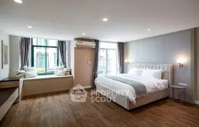 Spacious modern bedroom with elegant decor and large windows