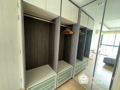 Spacious bedroom with modern built-in wardrobe and large mirror reflecting natural light.