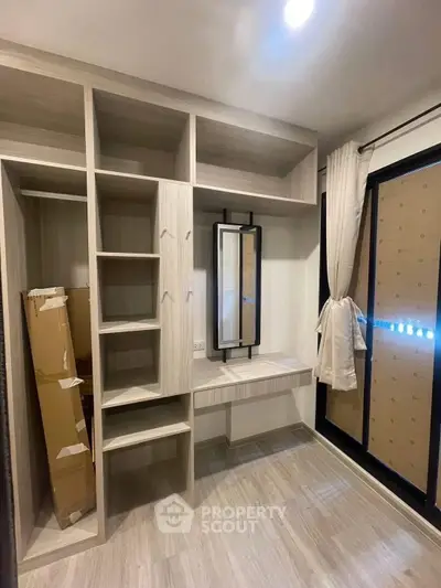 Modern walk-in closet with built-in shelves and mirror in a stylish apartment
