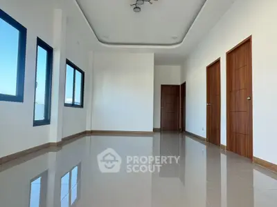 Spacious modern living room with glossy tiled floors and wooden doors