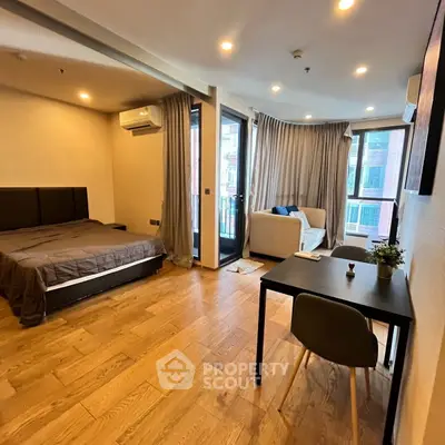 Spacious modern bedroom with balcony and wooden flooring in urban apartment