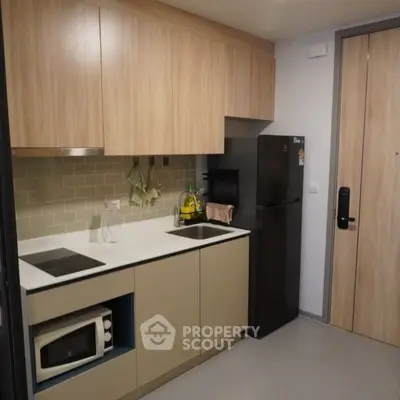 Modern kitchen with sleek cabinetry and appliances in a stylish apartment.