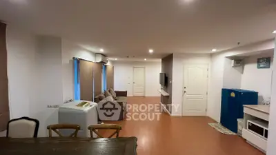 Spacious living room with modern furniture and appliances in a cozy apartment.