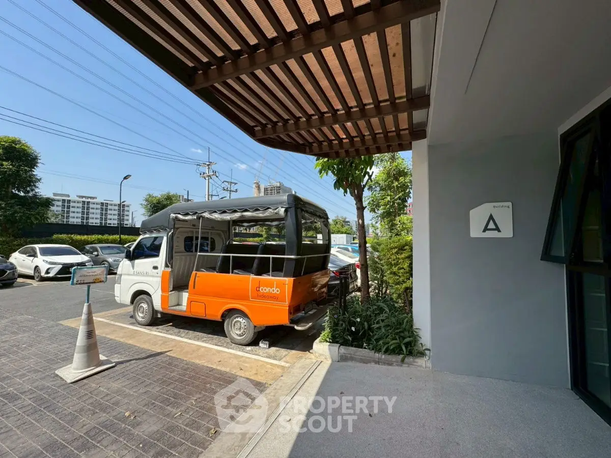 Modern condo entrance with shuttle service and parking area