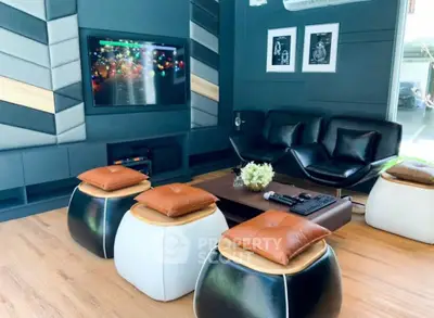 Modern living room with stylish seating and wall-mounted TV, perfect for entertainment and relaxation.