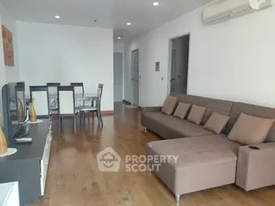 Spacious living room with modern furniture and wooden flooring in a stylish apartment.