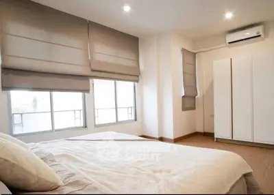 Spacious bedroom with modern decor and natural light