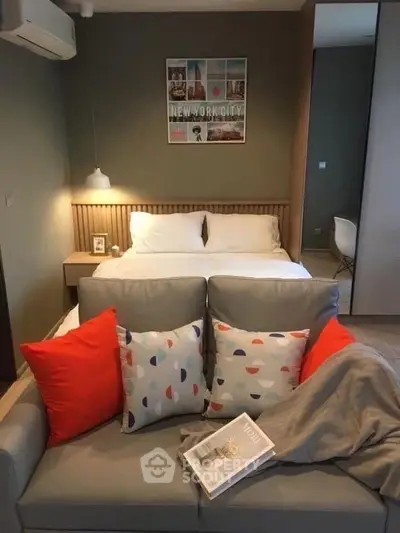 Cozy modern bedroom with stylish decor and comfortable seating area.
