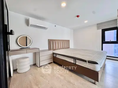 Modern bedroom with stylish furniture and large window offering natural light