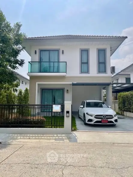 Modern two-story house with a sleek car parked in the driveway, showcasing contemporary architecture and lush greenery.