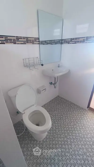 Modern bathroom with sleek white fixtures and stylish tile accents.