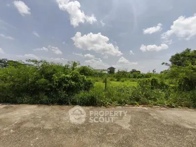 Expansive vacant land with lush greenery under a clear blue sky, perfect for development opportunities.