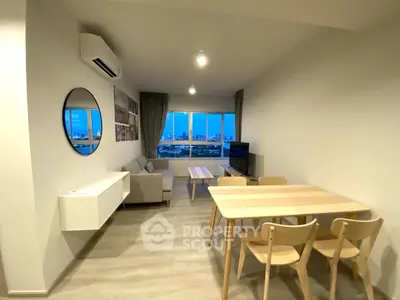 Modern living room with city view, stylish furniture, and air conditioning.