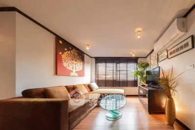 Spacious living room with modern decor and natural light, featuring a comfortable sofa and stylish furnishings.